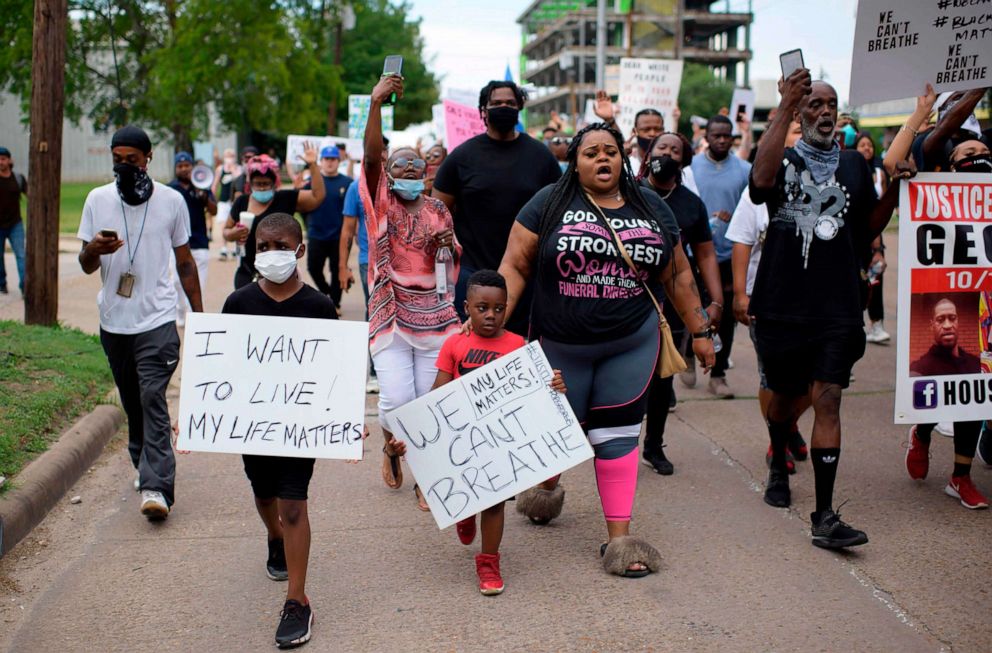 A group of people holding a sign